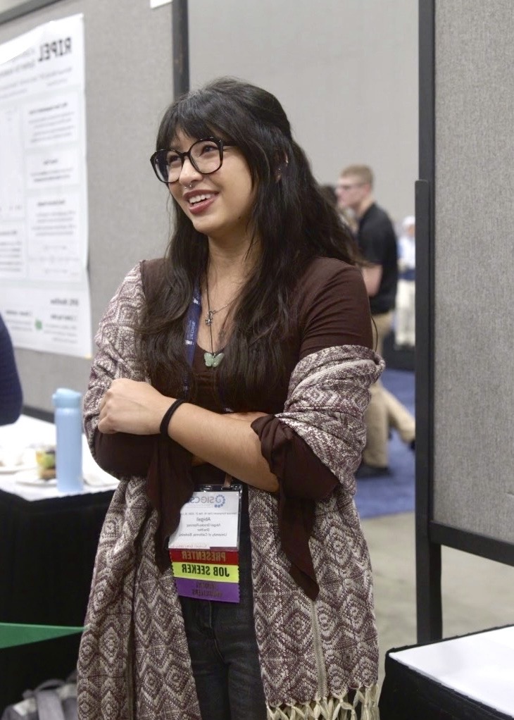 abby, a woman with tan skin and black hair with bangs. On mouse-over, an image of an orange cat and grey cat appear